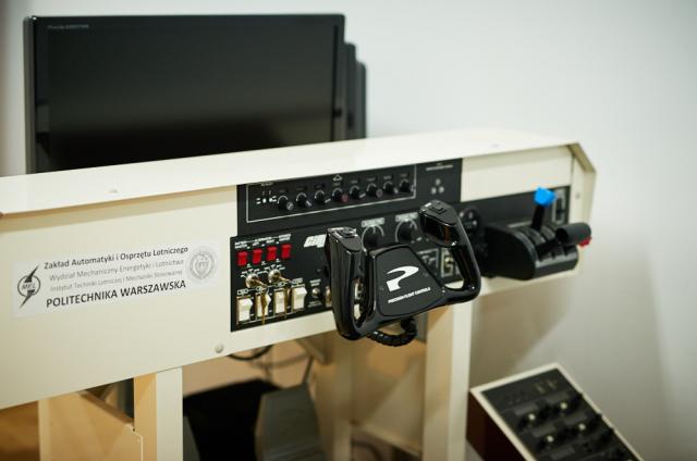 Zdjęcie przedstawia kabinę badawczą z wymiennymi sterownicami śmigłowca lub samolotu